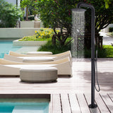 Outdoor shower with water flowing from circular head by poolside.