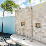 Brushed gold outdoor shower installed against a tiled wall with tropical scenery.