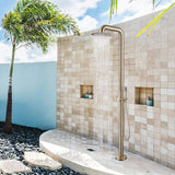 Brushed gold outdoor shower in use with water flowing from the overhead shower head.