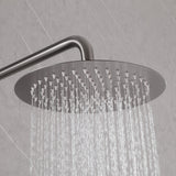 Gunmetal gray rainfall shower head with water flow, installed on a light gray tile wall